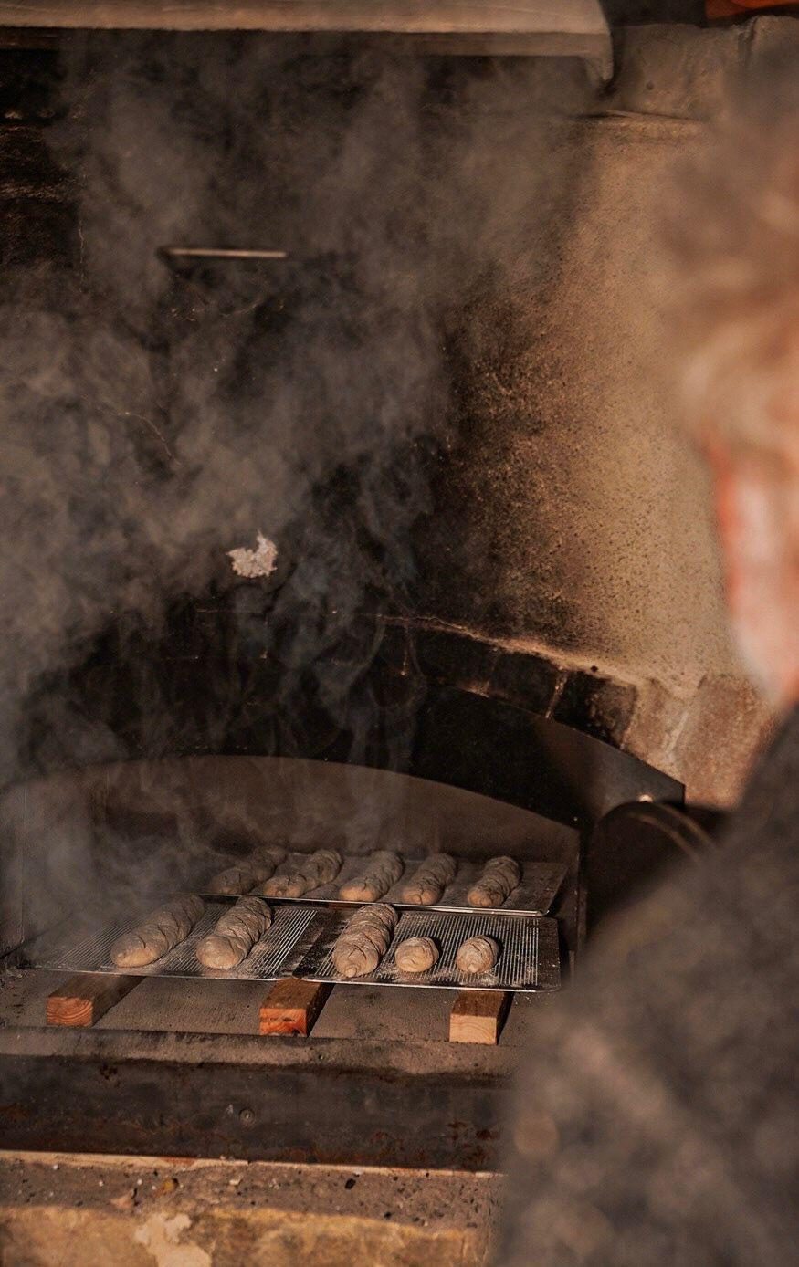 Frische Baguettes im rauchenden Holzbackofen