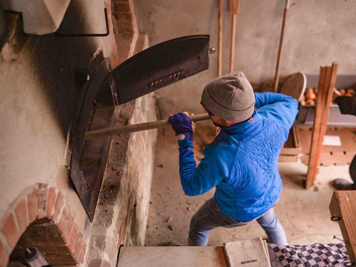 Manuel schießt Brot in den Holzbackofen ein